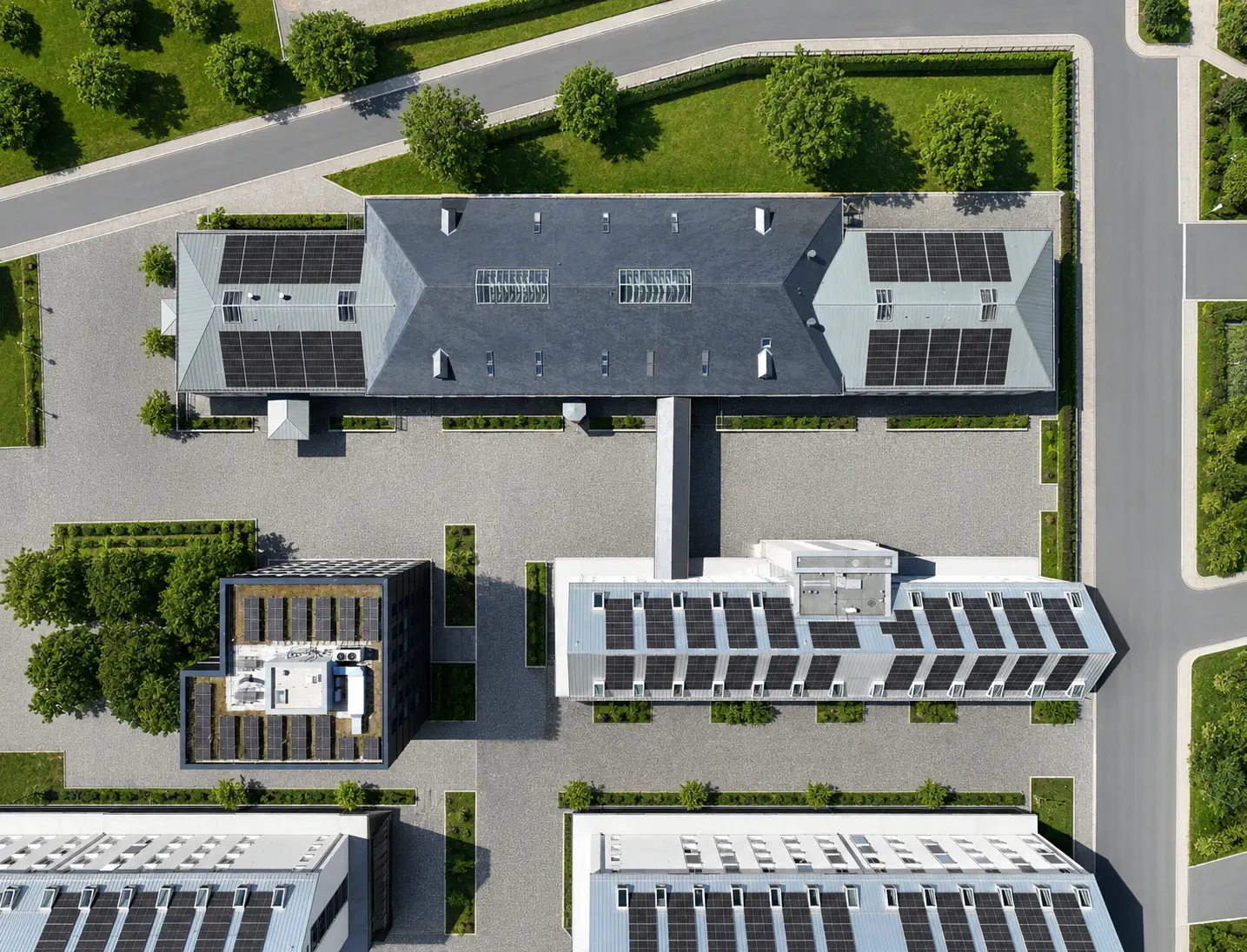 Aerial view of a company site with buildings and outdoor areas, surveyed by drone